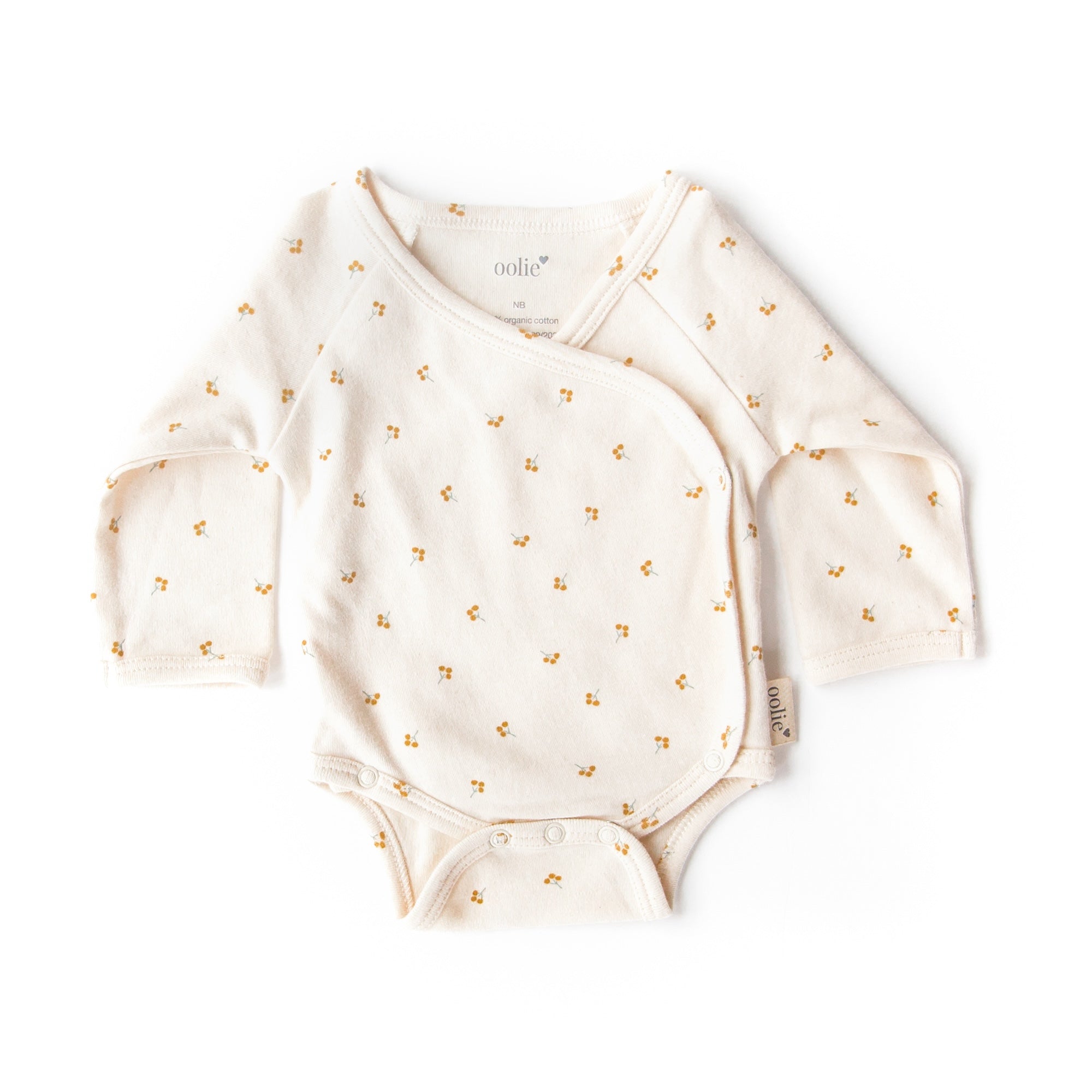 An Oolie organic cotton onesie with the gold sprig print, a natural color with small sprigs of golden berries.