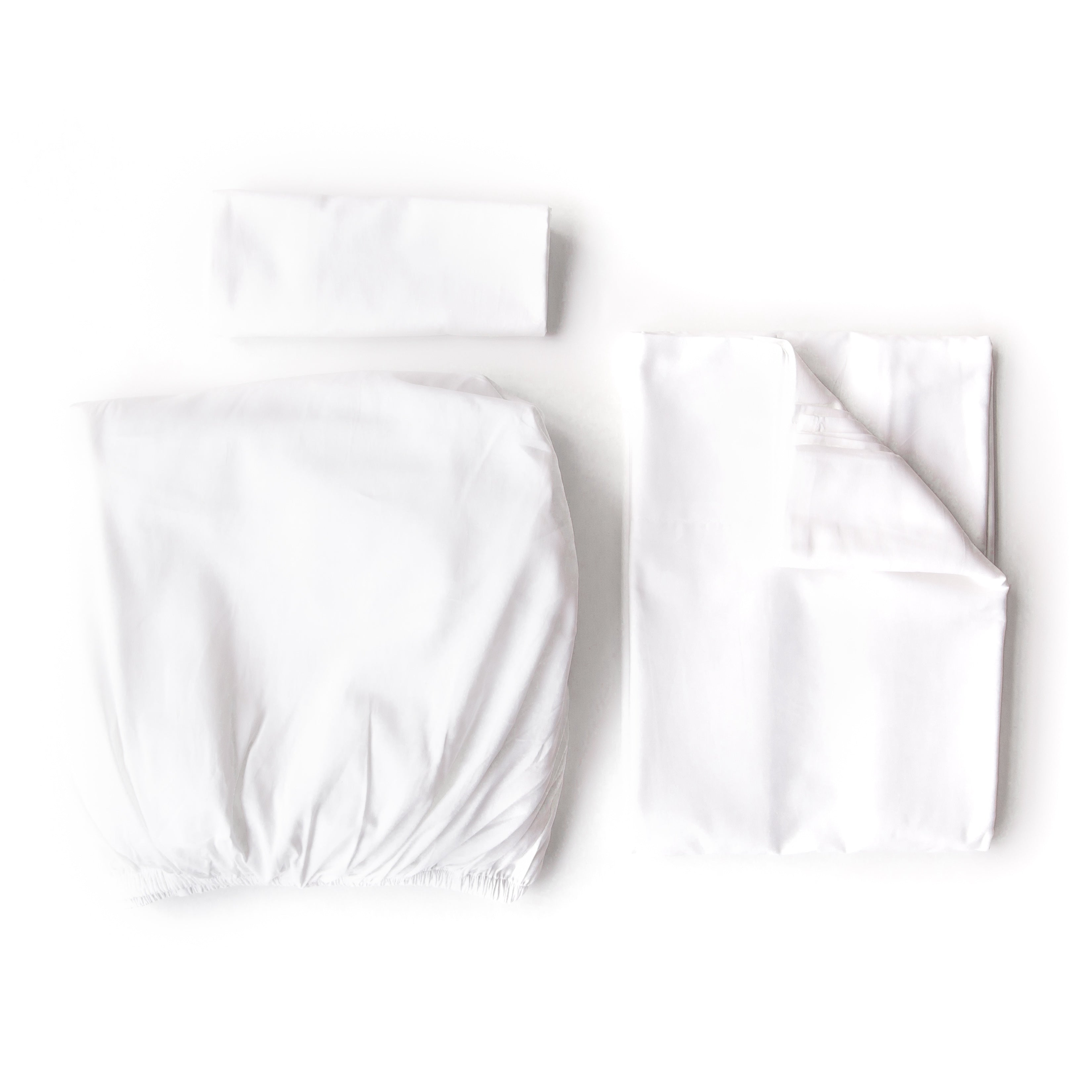 Oolie organic cotton pillowcases, flat sheet, and fitted sheet in white cotton, folded flat on a white background.