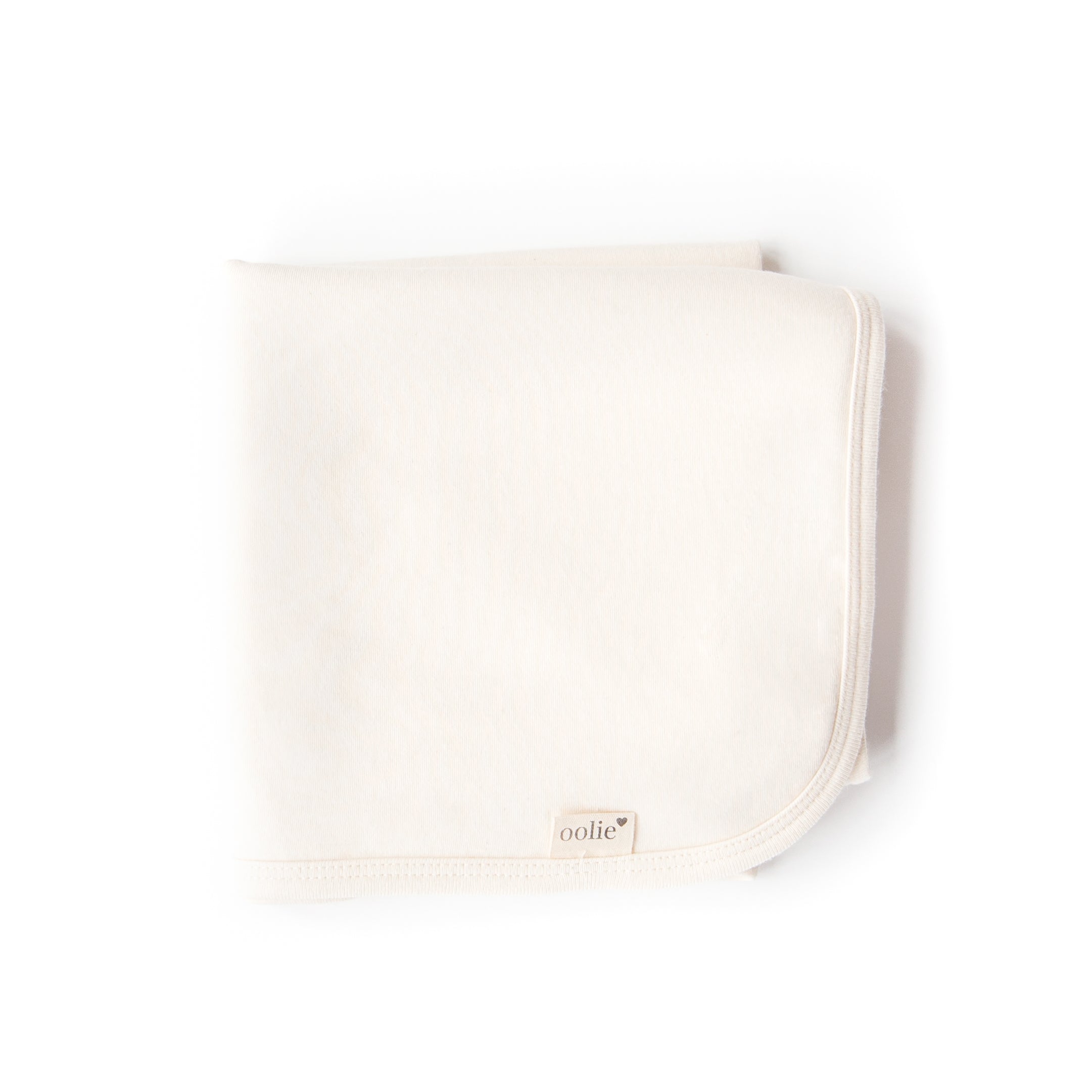 A natural Oolie organic cotton baby blanket, unprinted, revealing its natural, undyed, unbleached color.