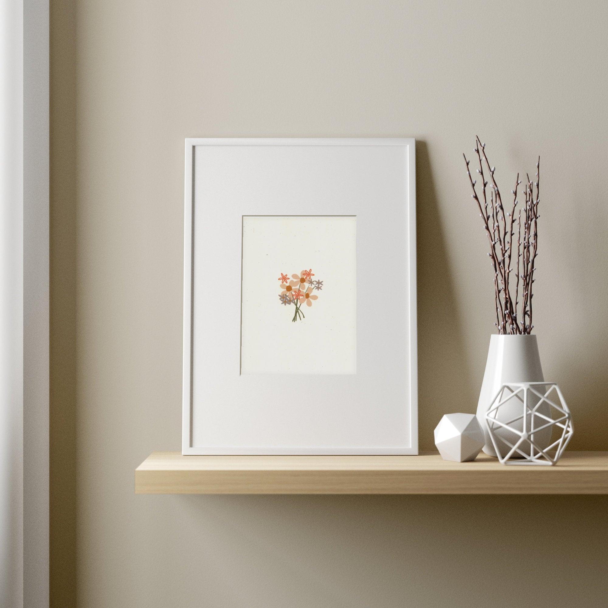 A cute nursery print of a bouquet of flowers on recycled, natural paper, framed, and set on a shelf with soft lighting.