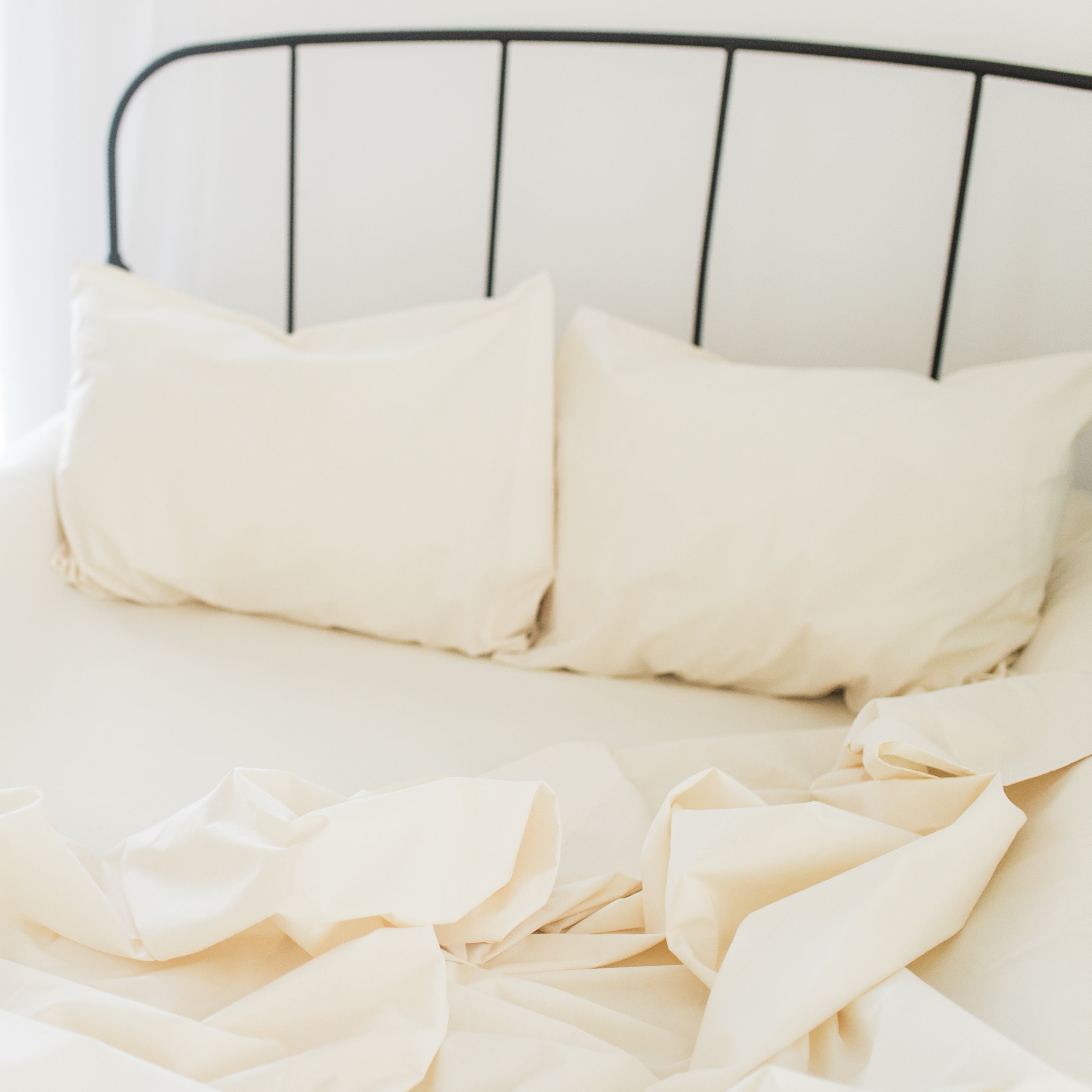 An Oolie organic cotton sheet set in natural, unbleached cotton installed on a full size bed.