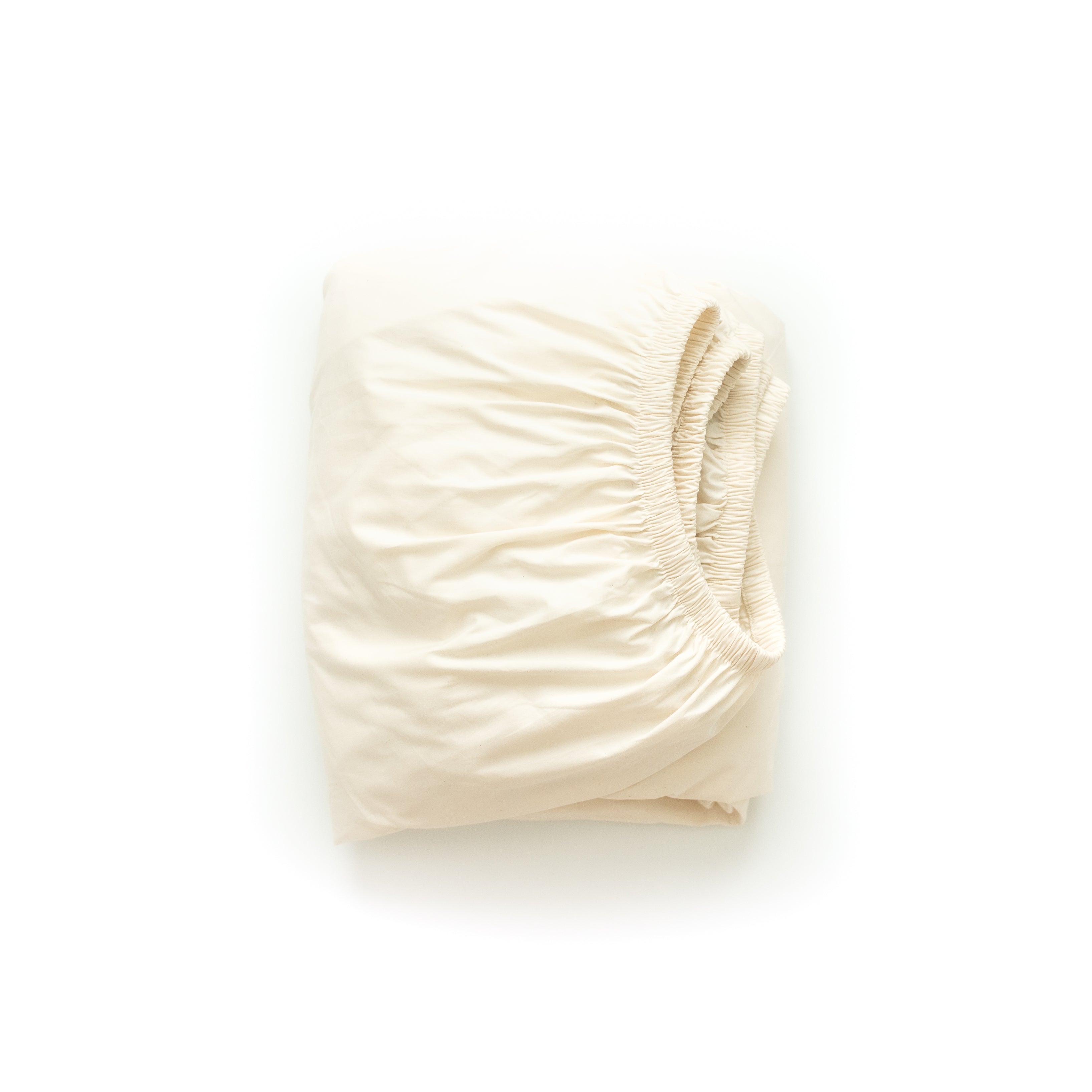 An Oolie organic cotton deep fitted sheet in natural, unbleached cotton, folded flat on a white background.
