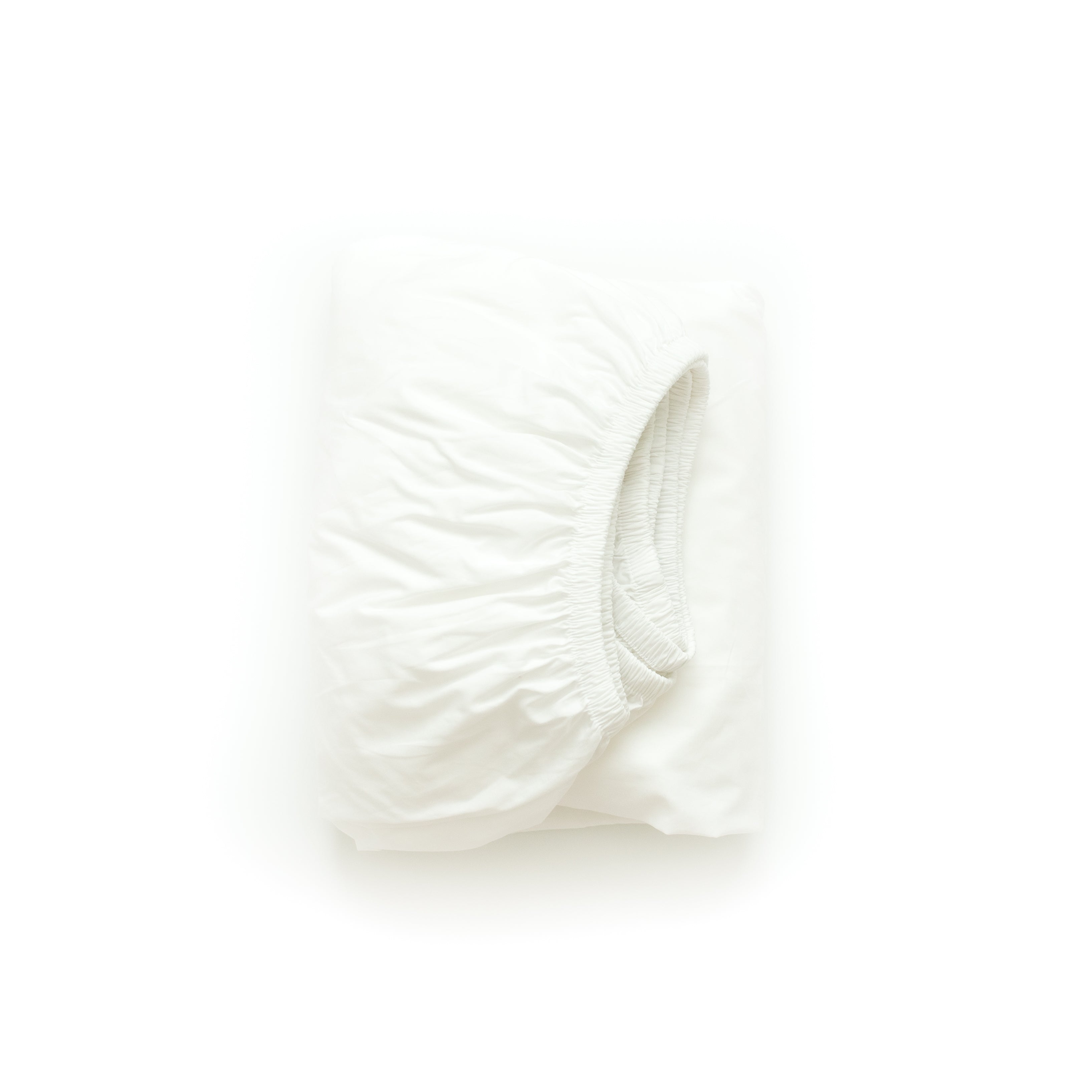An Oolie organic cotton deep fitted sheet in white cotton, folded flat on a white background.