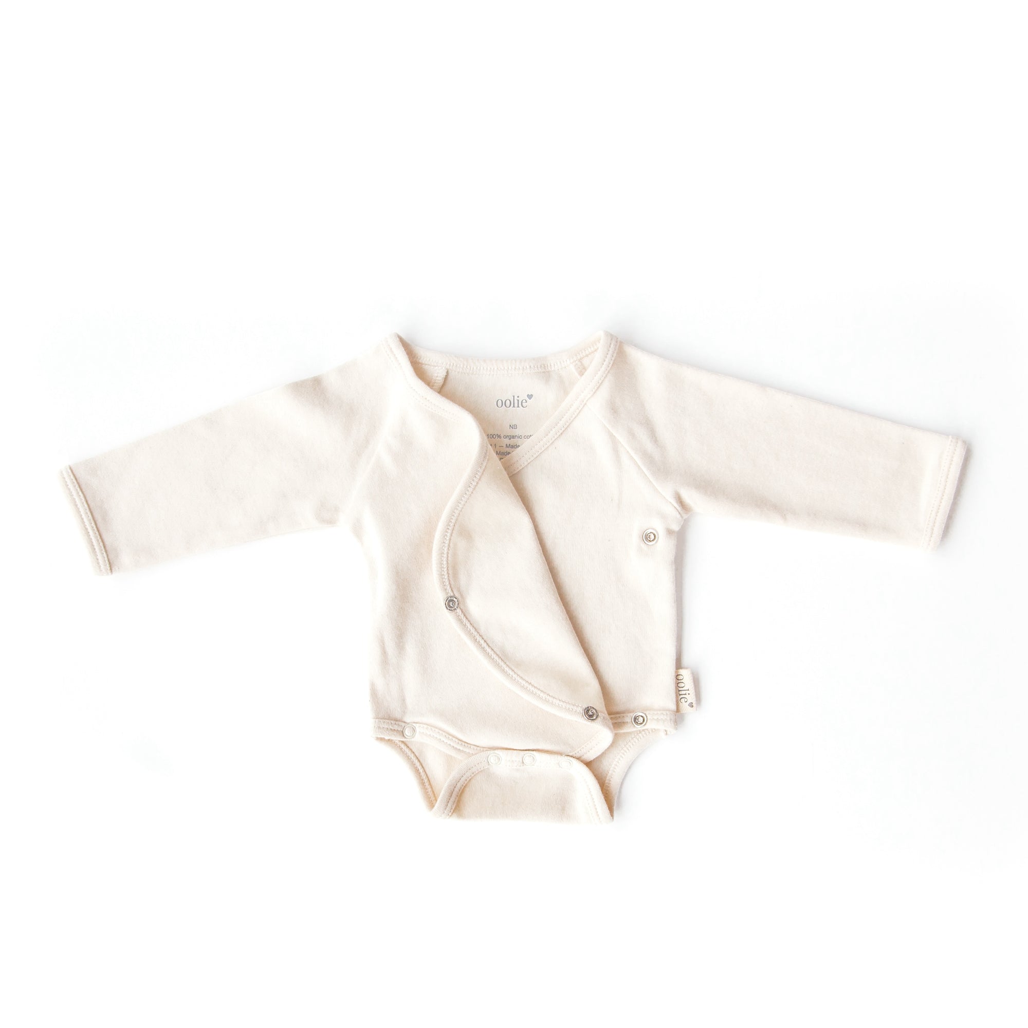 A natural color, Oolie organic cotton baby bodysuit, laid flat on a white background, with initial snaps unsnapped and the onesie&#39;s front flap folded back, kimono-style.