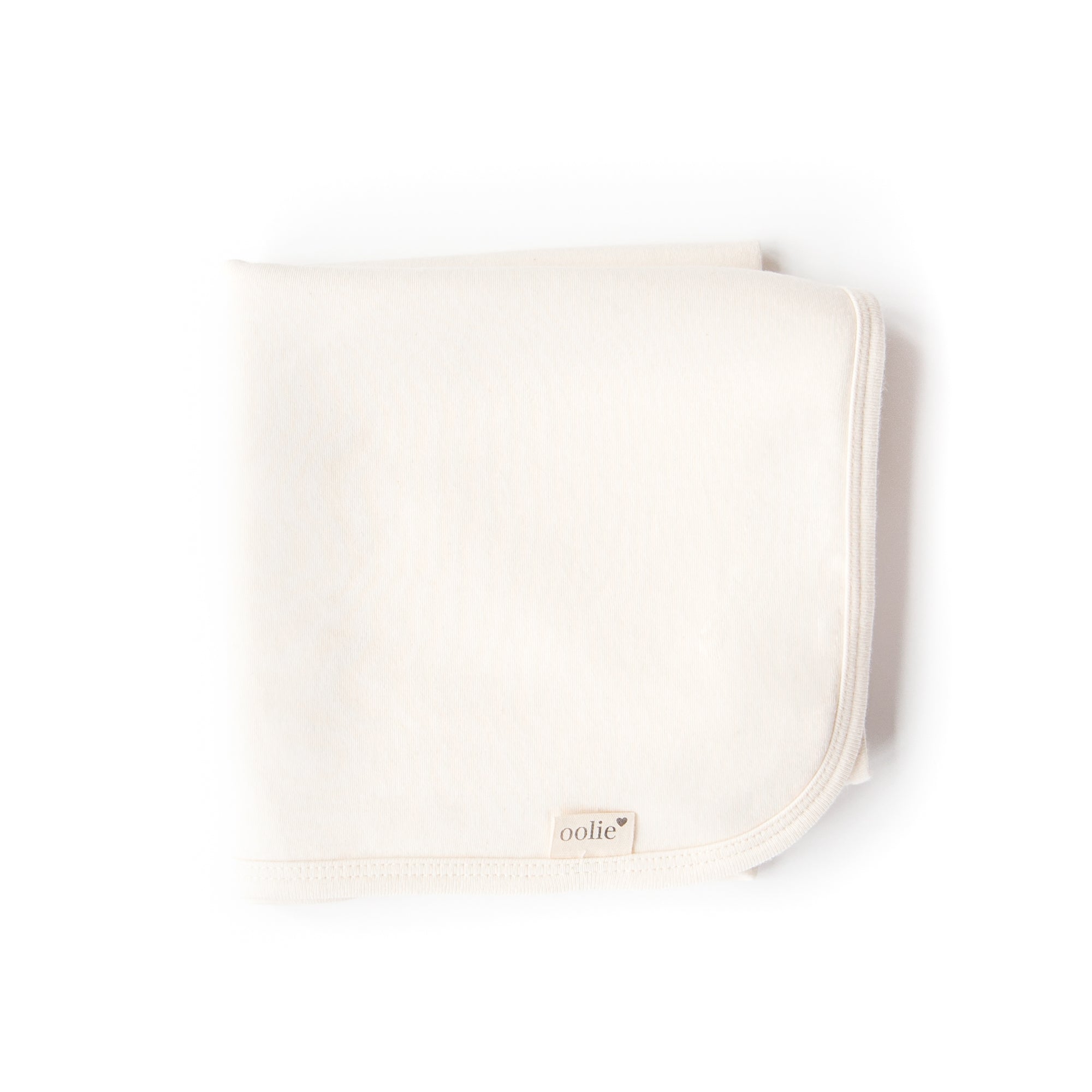 A natural Oolie organic cotton baby blanket, unprinted, revealing its natural, undyed, unbleached color.