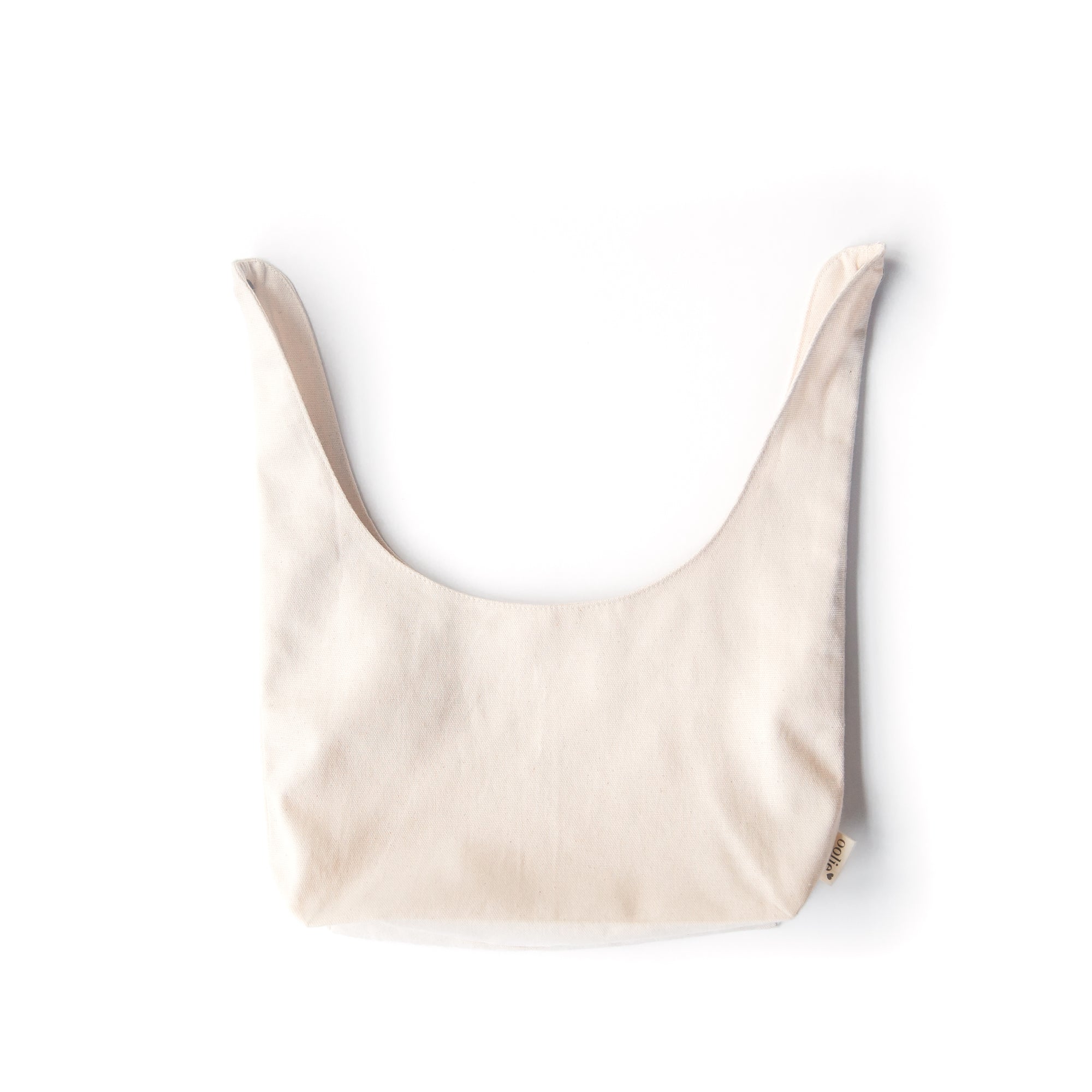 Oolie's organic convertible, organic bag made of natural color canvas, with its handle unsnapped and fully extended and laid flat, to show the shape of the bag.