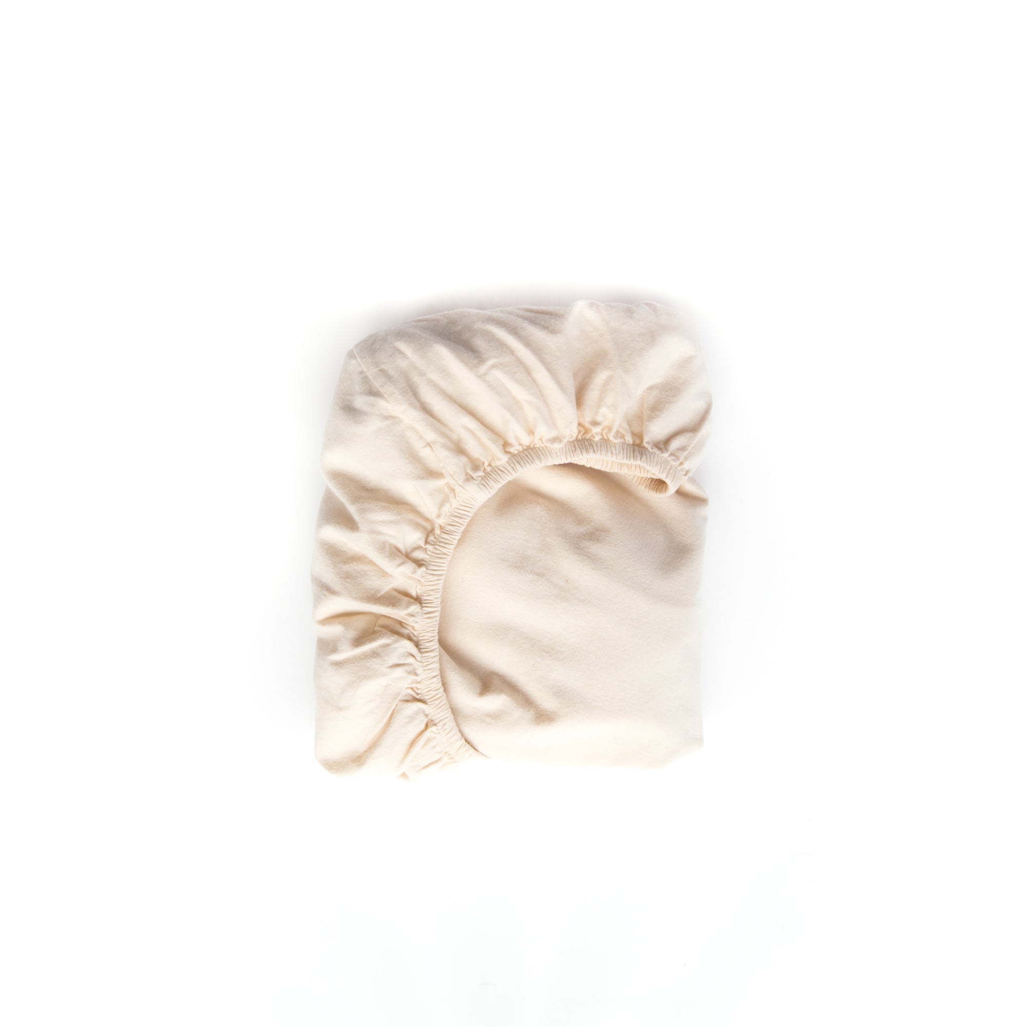 Oolie organic crib sheet, folded, in natural color, undyed fabric.